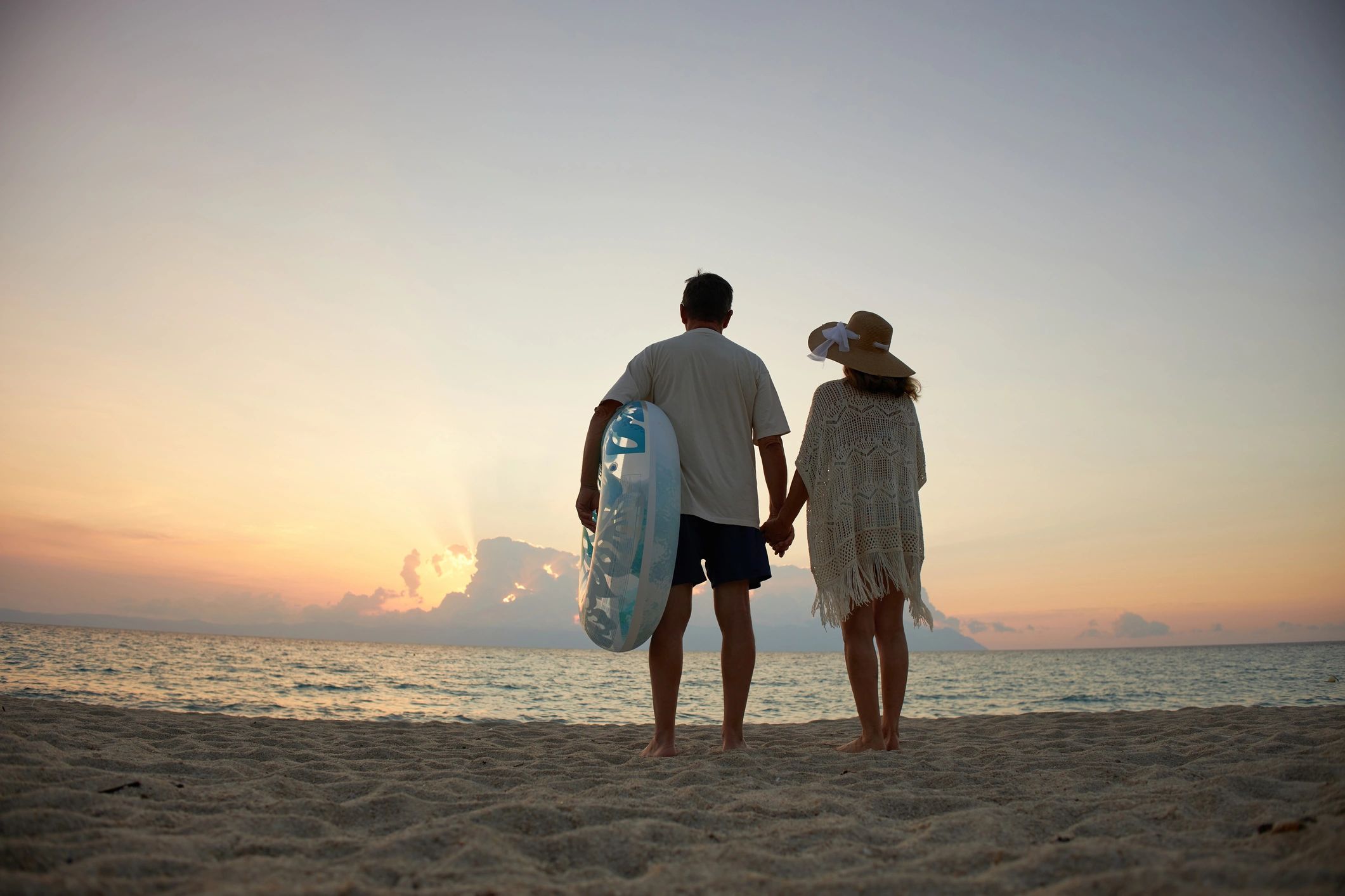 Couple watching sunset on a beach holiday